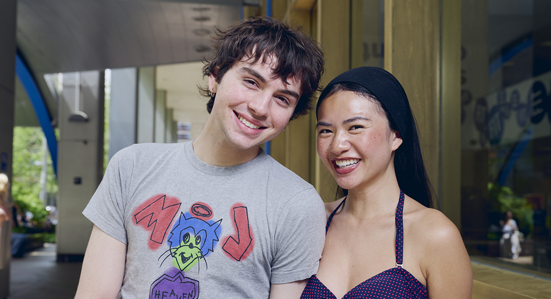 A guy and a girl smiling outside of Feldman Building